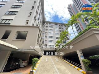 Exterior view of a multi-story residential building with a parking area