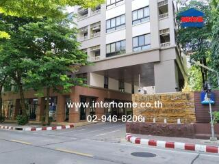 Exterior view of an apartment building with green surroundings.