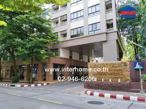 Exterior view of an apartment building with green surroundings.