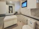 Modern bathroom with a vanity, toilet, and decorative plants