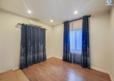 Bedroom with curtains and wooden floor