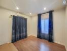 Bedroom with curtains and wooden floor