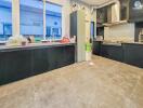 Modern kitchen with black cabinets and stainless steel appliances