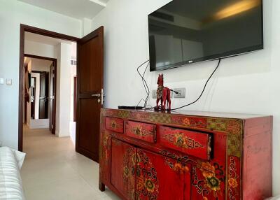 Living room with red decorative cabinet and mounted TV