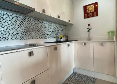 Modern kitchen with white cabinets and mosaic tile backsplash