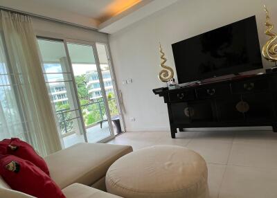 Bright living room with large TV and balcony view