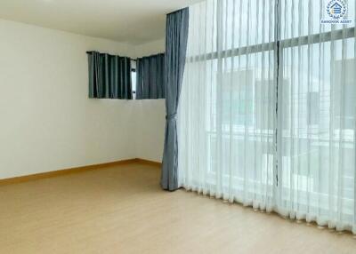 Spacious living room with large windows and curtains