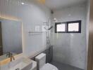 Modern bathroom with white ceramic wall tiles, sink, toilet, and walk-in shower