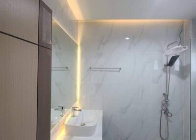 Modern bathroom with large mirror and illuminated vanity