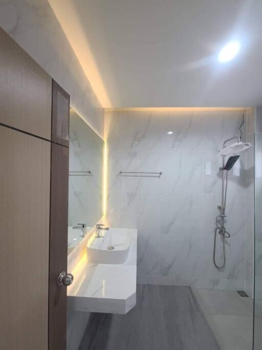 Modern bathroom with large mirror and illuminated vanity