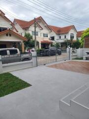 View of the front yard and the neighborhood with houses and parked cars