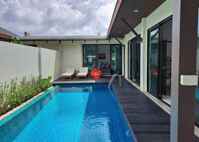 Outdoor pool area with lounge chairs and bean bag