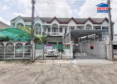 Front view of residential buildings with garage and gated entrance