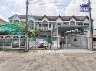 Front view of residential buildings with garage and gated entrance