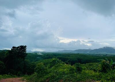 Beautiful scenic view of lush green landscape with mountains and cloudy sky