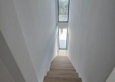 Bright staircase with wooden steps and a skylight