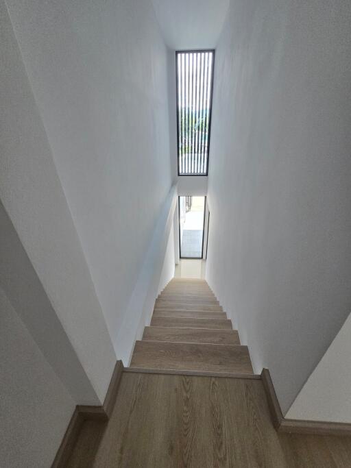 Bright staircase with wooden steps and a skylight