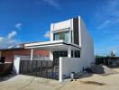 Modern two-story house with large windows and a spacious driveway