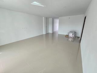 Large unfurnished room with glossy beige tiles