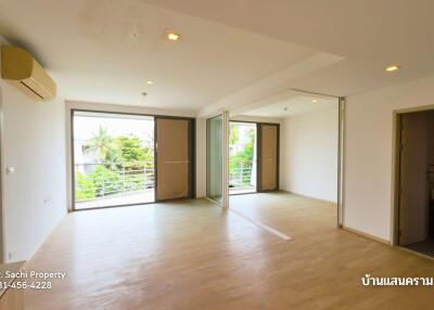 Spacious living room with large windows and wooden flooring