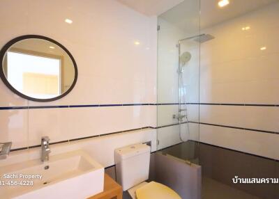 Modern bathroom with sink, toilet, and shower enclosure