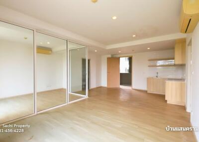 spacious living area with mirrored closets and glass doors leading to kitchen