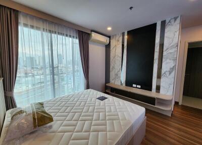 Modern bedroom with large window, air conditioner, and bed