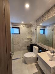 Modern bathroom with glass-enclosed shower and large mirror