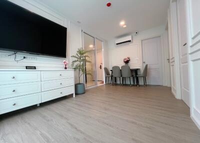 Modern living room with TV, dining area, and air conditioning