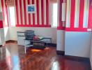 Bedroom with hardwood floors and red striped wallpaper