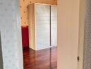 Bedroom with wooden wardrobe and hardwood floor