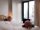 Cozy bedroom with large window and plush toys on the bed