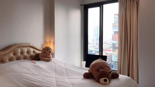 Cozy bedroom with large window and plush toys on the bed