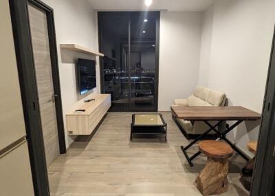 Modern living room with glass door, sofa, and a wooden table