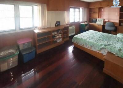 Spacious bedroom with wooden floor and large windows