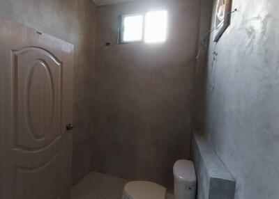 Minimalist bathroom with concrete walls and a small window