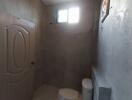 Minimalist bathroom with concrete walls and a small window