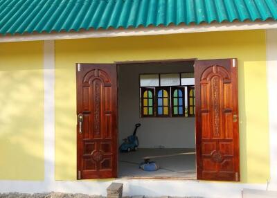 Exterior view of a building with an open double door and green tiled roof