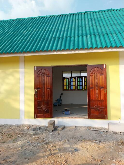 Exterior view of a building with an open double door and green tiled roof