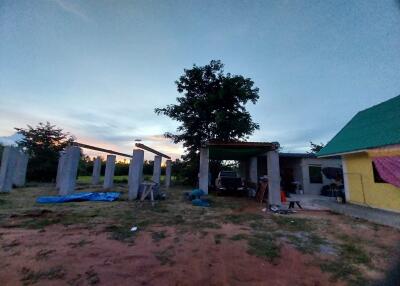 Outdoor view of construction site with an existing structure and tree