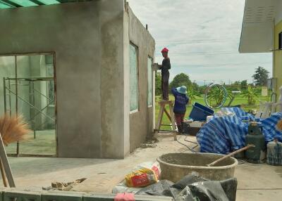 Building under construction with two workers outside