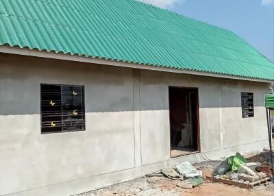 Exterior view of an under-construction house with a green roof