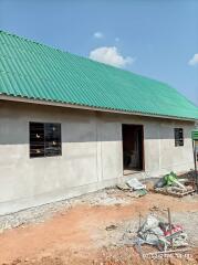 Exterior view of an under-construction house with a green roof