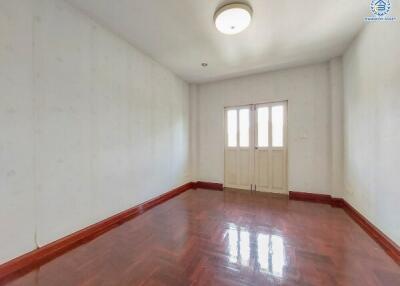 Empty bedroom with wooden floor and ceiling light