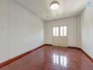 Empty bedroom with wooden floor and ceiling light