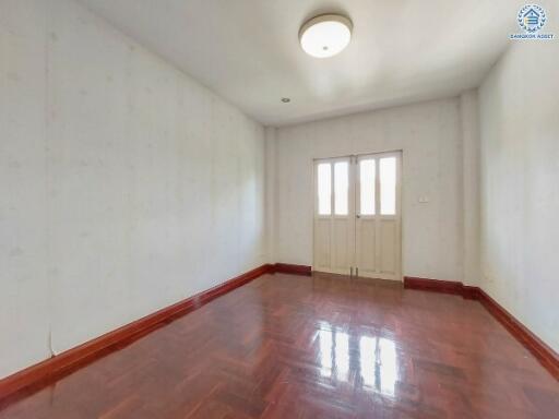 Empty bedroom with wooden floor and ceiling light