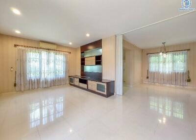 Spacious living room with large windows and built-in entertainment unit.