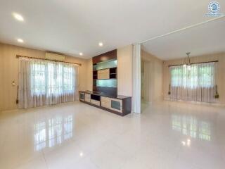 Spacious living room with large windows and built-in entertainment unit.