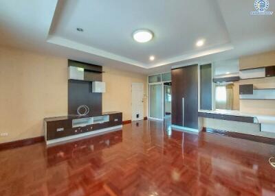 Spacious living room with wooden flooring and modern built-in storage units