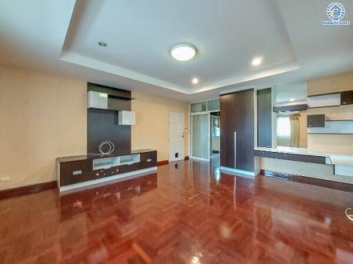 Spacious living room with wooden flooring and modern built-in storage units